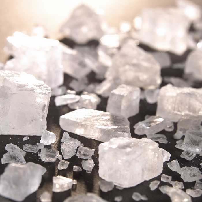 Various shapes and sizes of rock salt on a black table.