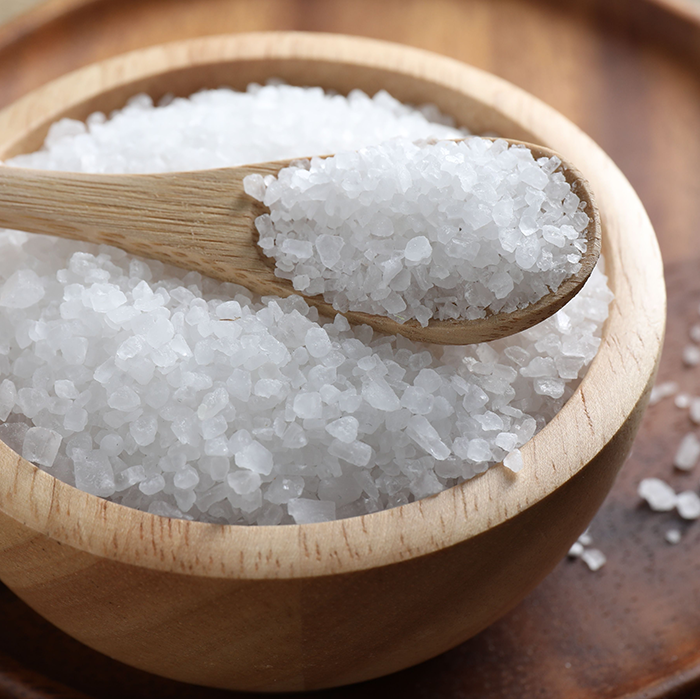 A wooden bowl and spoon holding table salt